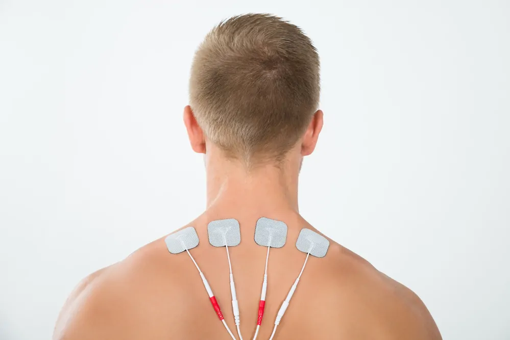 Mann mit Tens Elektroden am Nacken